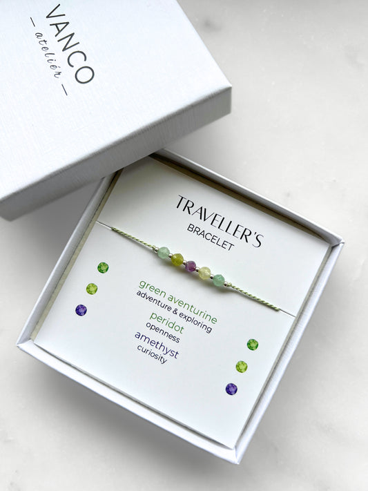 Green silk cord bracelet with natural crystals in a white gift box, titled Traveller's Bracelet.