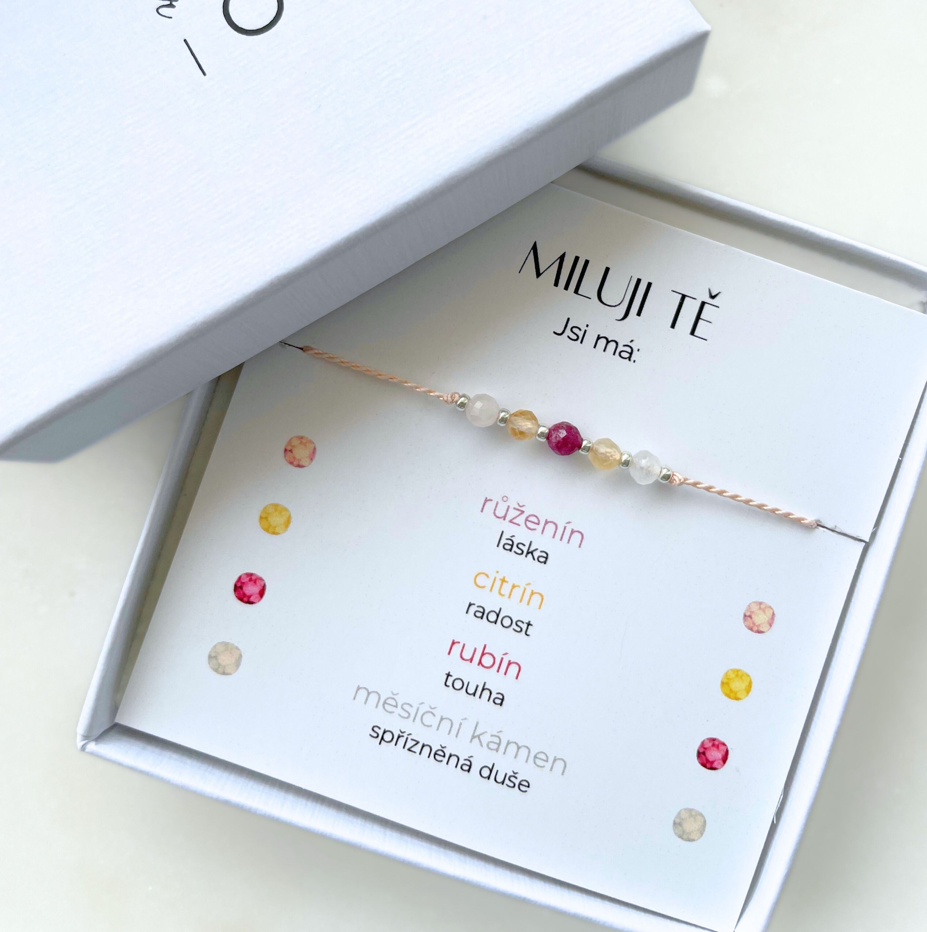 Náramek "Miluji tě" na růžové šňůrce s růženínem, rubínem, měsíčním kamenem a citrínem v bílém dárkovém balení.