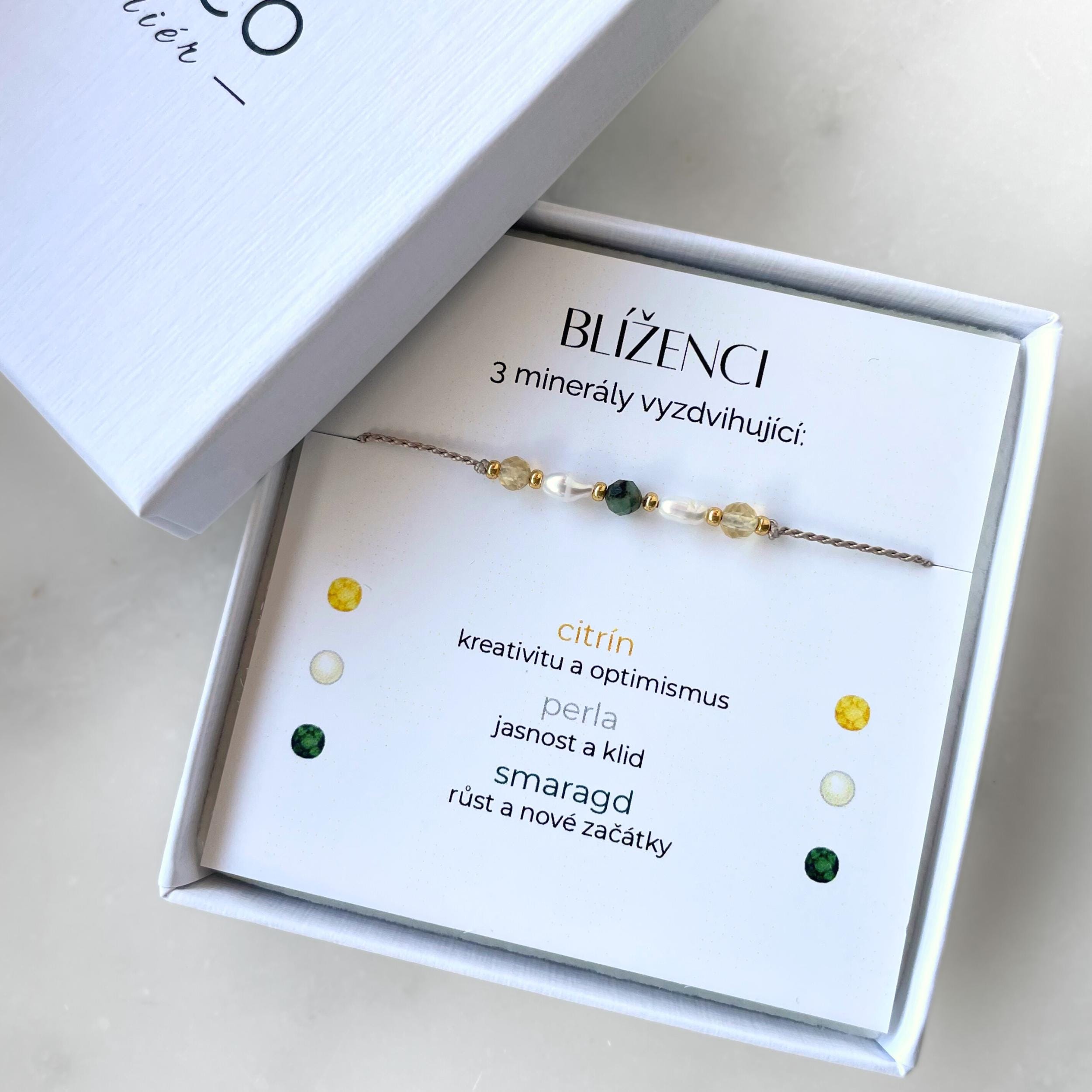Minerální náramek na hedvábném provázku vytvořen pro znamení Blíženci v bílé dárkové krabičce s promo textem, který vysvětluje výběr minerálů.